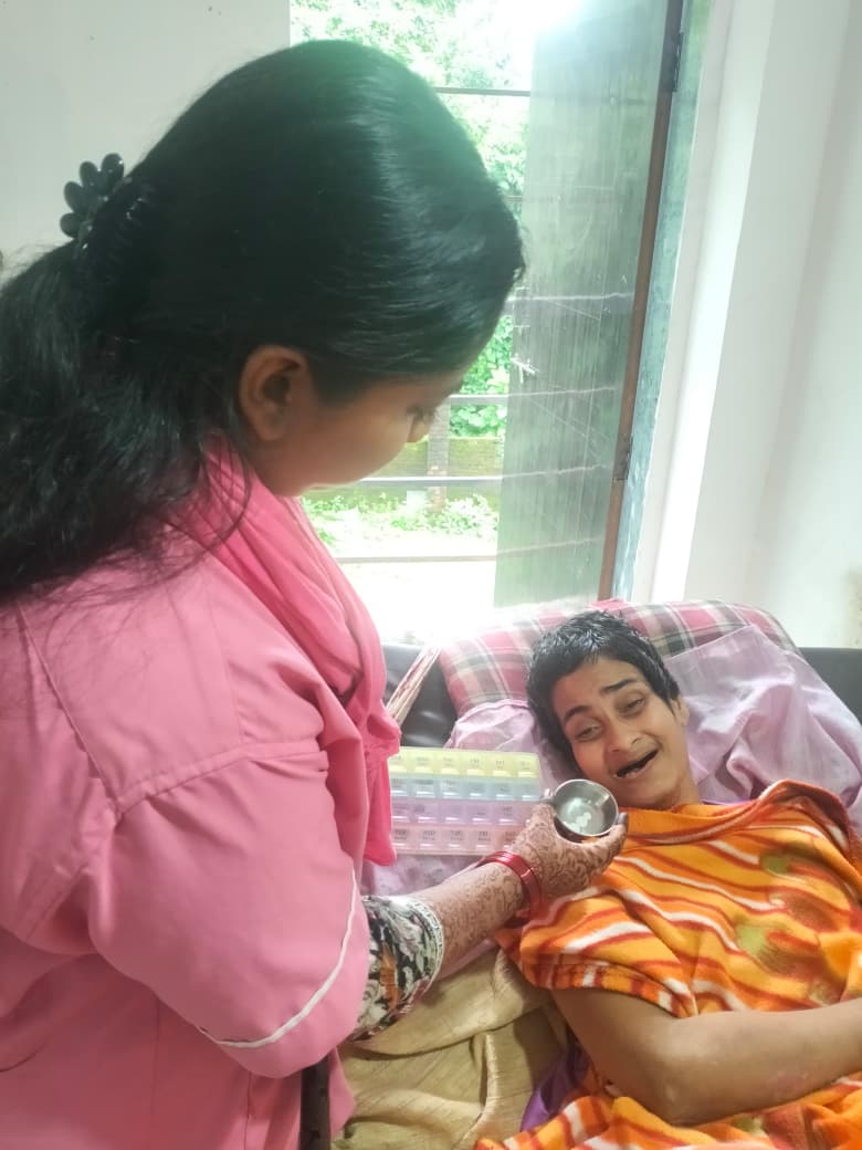 Caregiver giving medication to an elderly patient